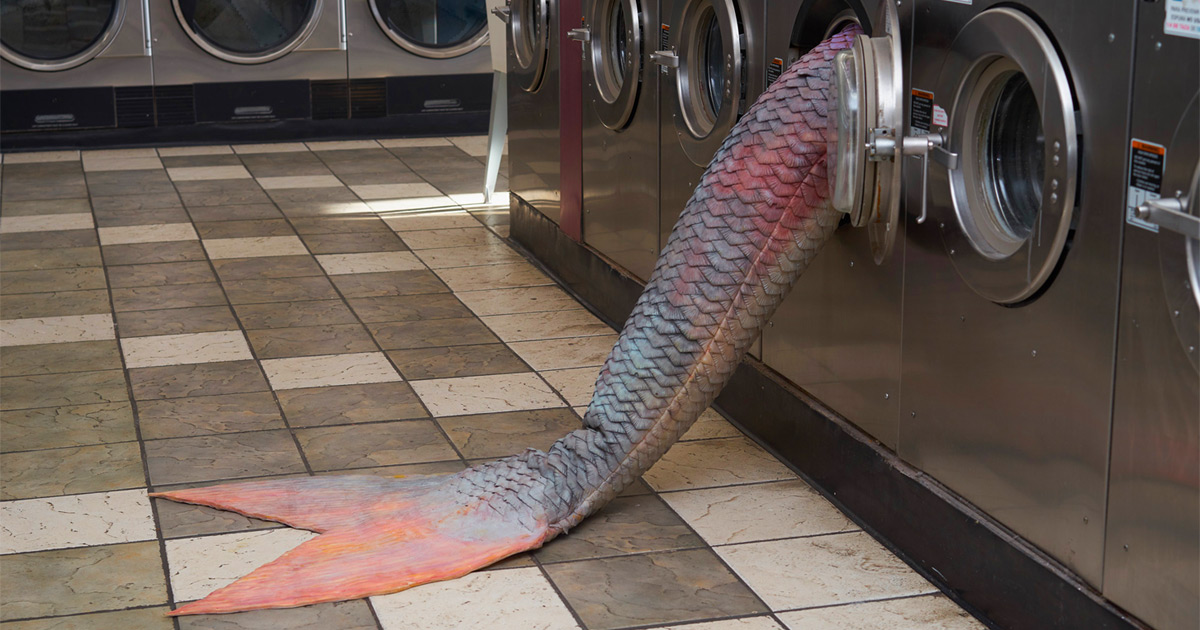 Artista instala caudas de sereia misteriosas nas máquinas desta lavanderia